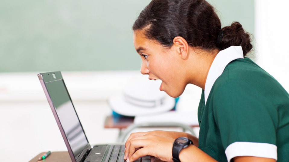 Student on a laptop working on challenges for computing