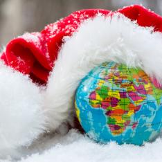 Globe in snow with a santa hat placed on the top