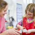EYFS pupil practising using their fine motor skills with their teacher, fine motor skill ideas being carried out in the classroom