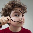 Child Holding A Magnifying Glass Solving A Mystery/looking At Something Closer as part of a murder mystery activity at Primary