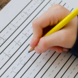 Pupil using a handwriting resource line guide to practice hand writing skills