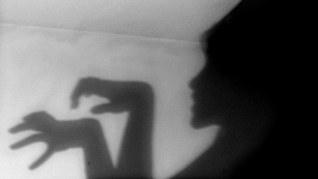 Spooky shadow ghost on a wall scare off parents engagement school