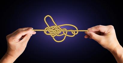 Tangled knot, with hands pulling at it
