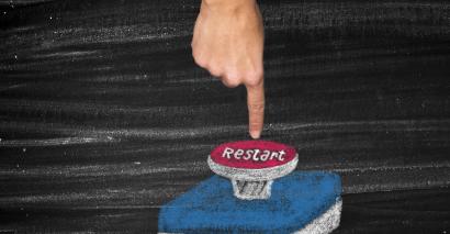Finger pressing down on large 'Restart' button