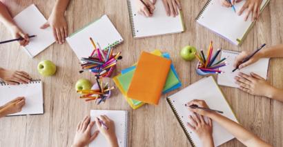 Primary pupils with notebooks starting to think of different ideas and writing types to start their writing