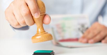 Unrecognizable person is about to stamp an important document.