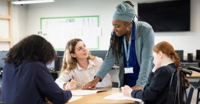 Teacher in classroom talking to pupil