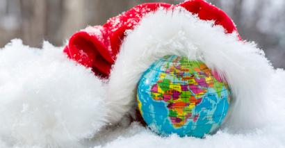 Globe in snow with a santa hat placed on the top