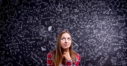 Secondary maths student in front of a chalk board of mathematical workings as they use fun maths resources to make learning stick