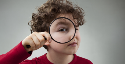 Child Holding A Magnifying Glass Solving A Mystery/looking At Something Closer as part of a murder mystery activity at Primary