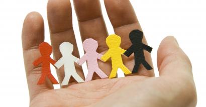 Paper people on a person's hand to signify People Who Help Us Resources