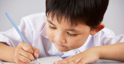 Young Child Writing To Demonstrate Comprehension Tasks Within Primary English Lessons