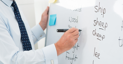 Image Of Teacher Writing Spellings On A Whiteboard For KS1 & KS2 Pupils