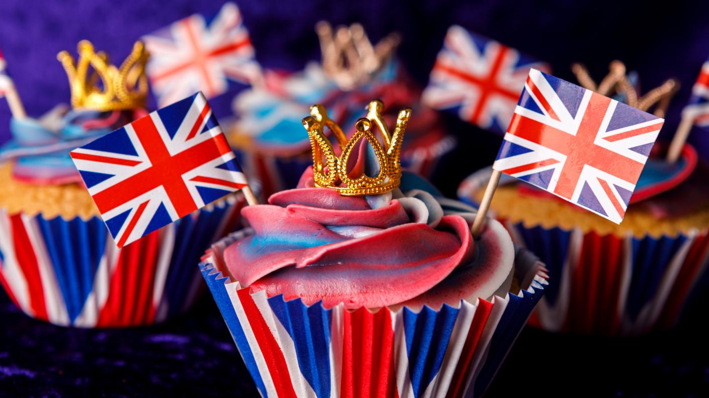 Cupcakes sat on a table decorated with crowns and union jacks ready for the Kings coronation celebration, primary teaching resources for King Charles III coronation