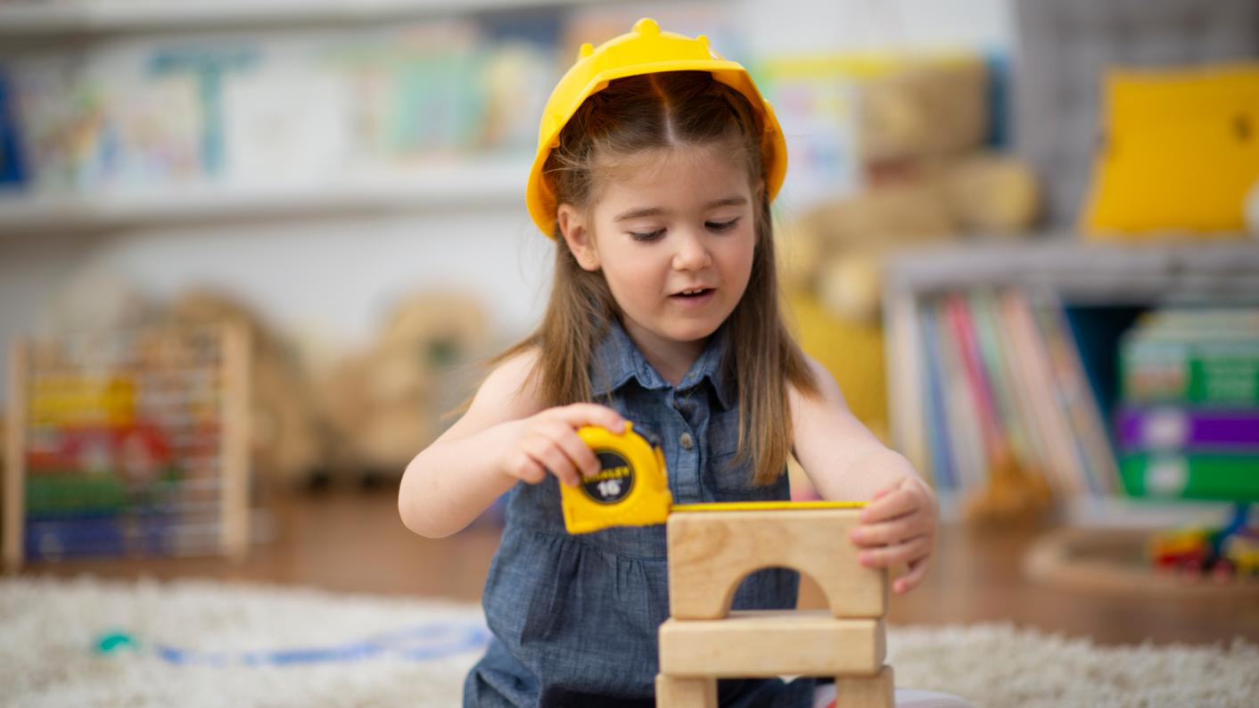 Child playing with construction area resources for EYFS and Primary
