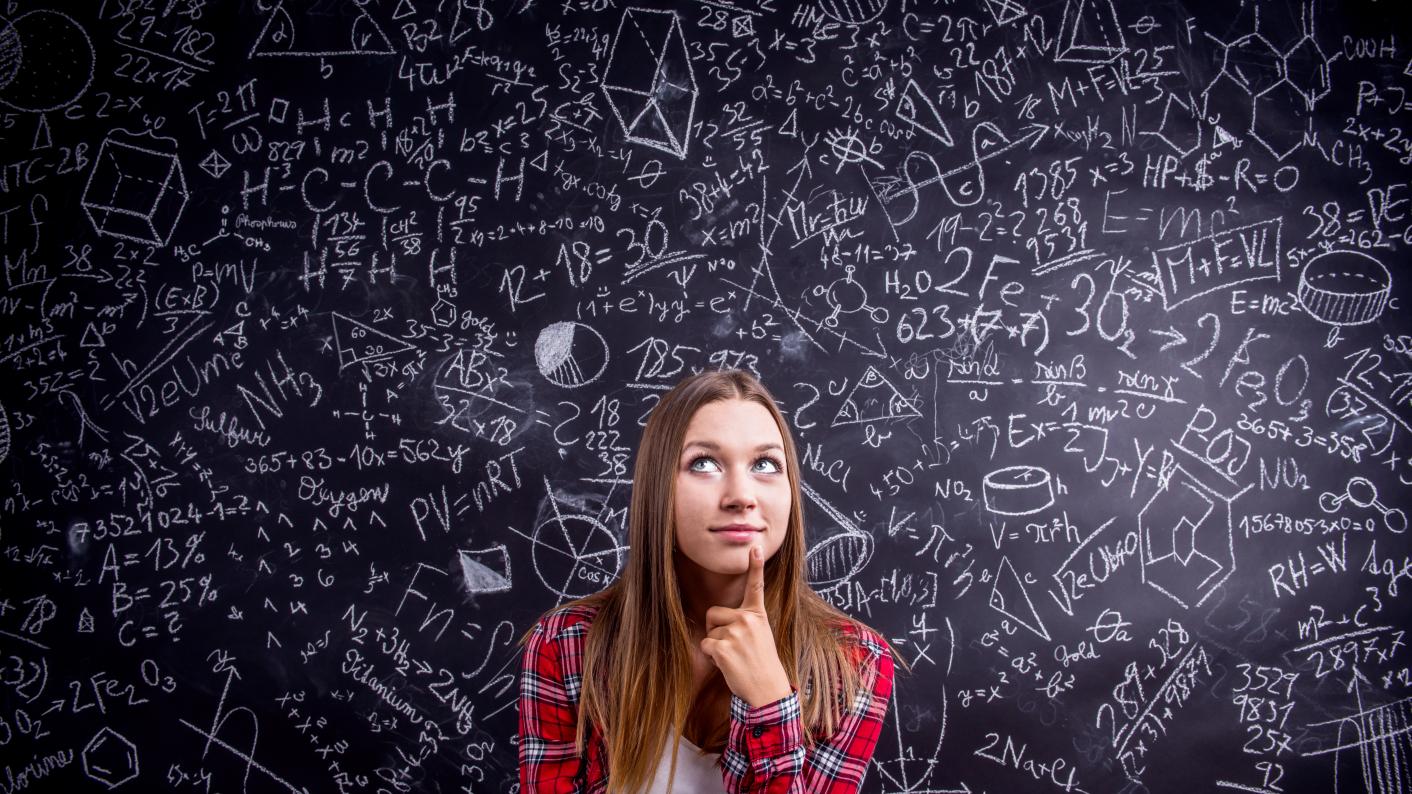 Secondary maths student in front of a chalk board of mathematical workings as they use fun maths resources to make learning stick