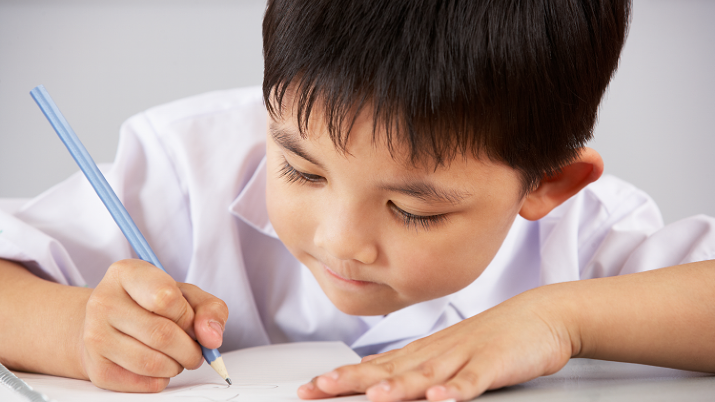 Young Child Writing To Demonstrate Comprehension Tasks Within Primary English Lessons