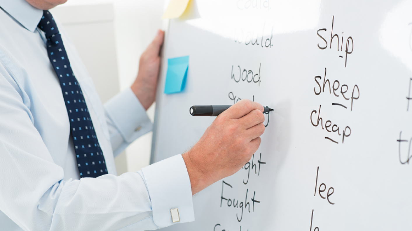 Image Of Teacher Writing Spellings On A Whiteboard For KS1 & KS2 Pupils