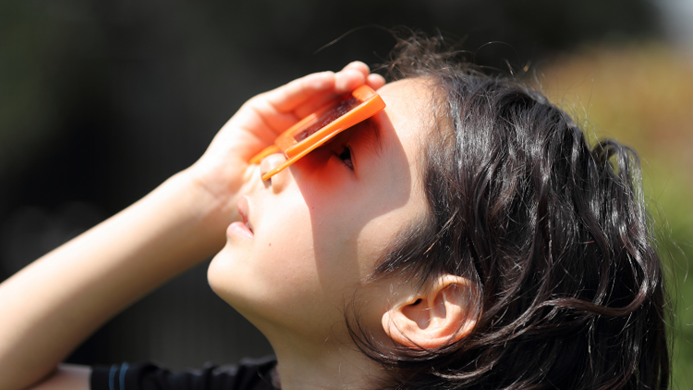 A Girl Looking Up Wearing Solar Eclipse Glasses