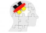 Man's head as jigsaw puzzle, with one piece in colours of German flag
