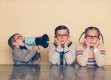 T levels: A small boy shouting through a megaphone at two girls with hands over their ears