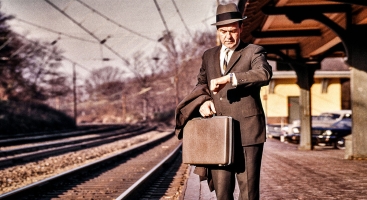 man looking at watch at train station