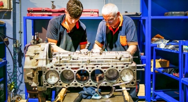 Two men fixing an engine