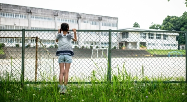 Girl at school fence