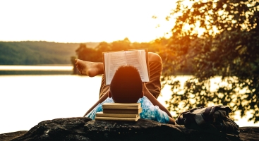boy reading by lake