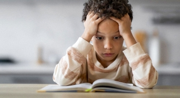 Child puzzled reading a book