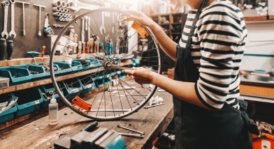 person working with bicycle wheel