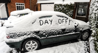 Car in snow with day off written on windows