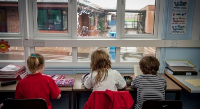 Children in classroom with broken window