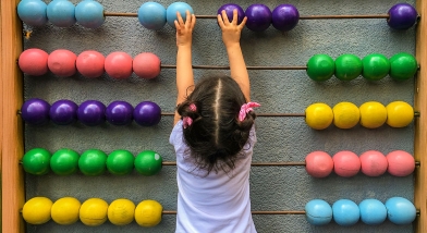 Small child counting on an abacus