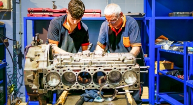 Two men fixing an engine