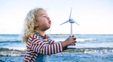 Small child blowing on windmill Sustainability Scotland