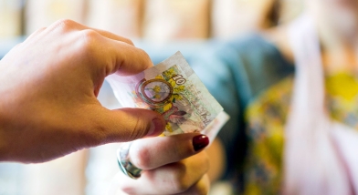 A person handing another person a tenner