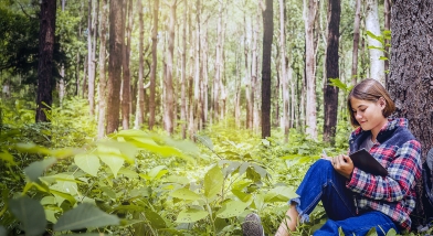 Girl writing in a forest