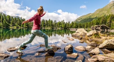 Woman stepping across a stream