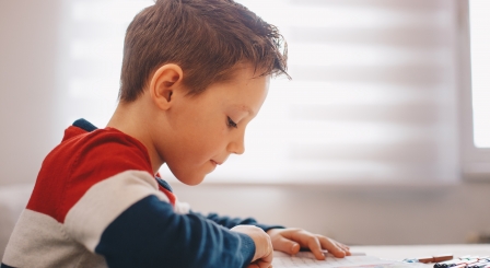 pupil reading from a page with finger following words