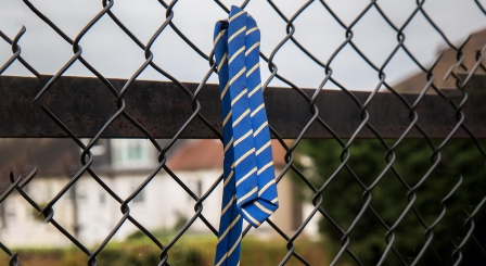 School leavers tie on fence