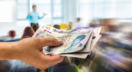 Hand with money in classroom