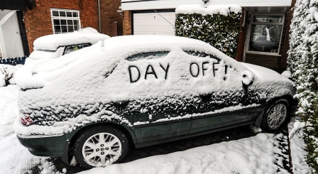 Car in snow with day off written on windows