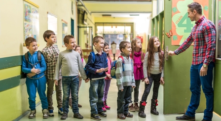 Teacher welcoming pupils to class