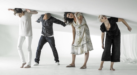 Four people pushing against ceiling