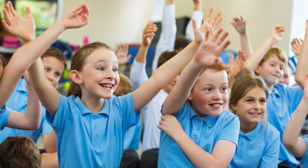 School children with their hands up