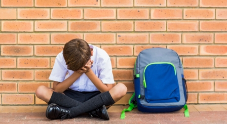 Pupil sitting against a wall