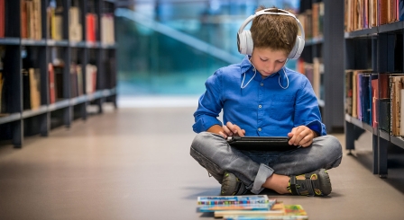 Child listening to audio in library