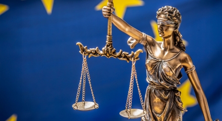 Scales of justice with Euro flag in background