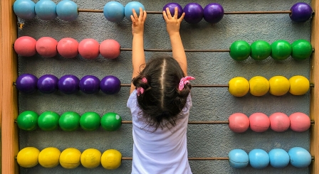 Small child counting on an abacus